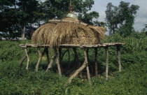Maize store on raised platform with straw lid