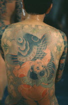 Heavily tattooed Yakuza gangster with back to camera.