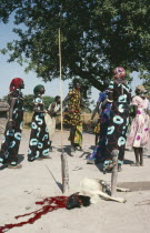 Dinka sacrificial ceremony.  The three women wearing the same dress are all married to the same man.