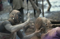 Dinka hairdressing.  Hair is trimmed into shape and dyed with cattle urine.