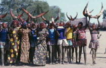 Dinka cattle festival or Toich.  Women holding painted bulls horns in the air.