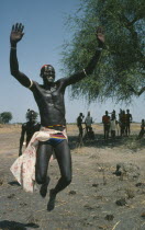 Dinka tribesman leaping into air.