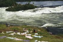 View over the river and source of the Nile with people drying cloths on the bank in the foreground