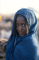 Girl in blue shawl with light facial scarification wearing a hooped nose ring