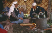 Kazakh nomadic women brewing tea in their Kigizuy or felt tent in the Altay Mountains