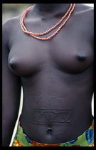 Symmetrical pattern of raised scars decorate the abdomen of a young Dinka woman