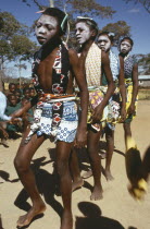 Makonde girls wearing ritual face whitening and dancing during female initiation ceremony.