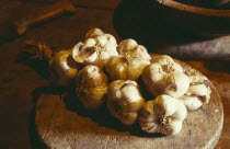 Garlic lying on wooden board on table.