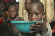 Karamoja.  Feeding project for vulnerable people.  Child receiving bowl.
