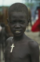 Dinka boy.  Head and shoulders portrait wearing cross on string around neck.