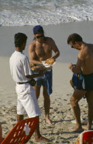 Man selling pizza to tourists on the beach