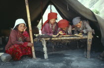 Group of Kirghiz children inside tent studying the Koran.