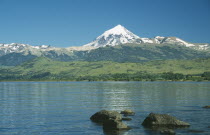 View over bolders of Huechulafquen Lake toward snow capped Lanin Volcano.