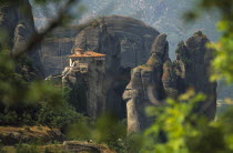 Monastery  amongst eroded rock pinnacles  seen through tree branches.