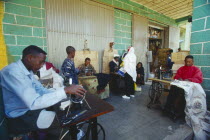 The Mercato  Africas largest market.  Group of men using hand powered sewing machines.