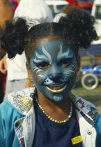 Girl with face painted with cat design.