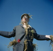 Human scarecrow with straw stuffed jacket.