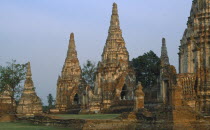 Wat Phanan Choeng Temple on the bank of the Chao Phraya river. Group of Stupas with visitors walking in grounds.