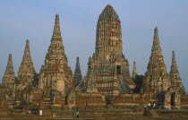 Wat Phanan Choeng Temple on the bank of the Chao Phraya river. Group of Stupas with visitors walking in grounds.