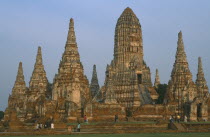 Wat Phanan Choeng Temple on the bank of the Chao Phraya river. Group of Stupas with visitors walking in grounds.