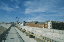 Old Portsmouth. Path with railings and seats next to the Walls and row of buildings to one side.