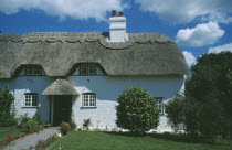 Thatched Cottage seen from across green front lawn.
