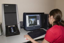 Female technician scanning analogue slide film with an Imacon scanner