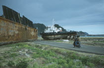 Indonesia, Tsunami, Aceh Province, Two large metal ships dumped on middle of a road outside Banda Aceh town by wave.