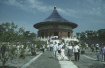 Temple of Heaven with Chinese tourists walking on path. Peking
