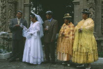 Wedding in El Monticulo. Bride and guests standing under archway.