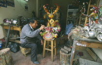 Man in a workshop working on a mask.