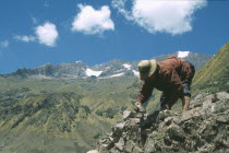 Local Quechuan man building a house  mountains in the distance. Cuzco  Sacred Valley  Andes Cuzco  Sacred Valley  Andes
