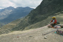 Quechuan Indian woman weaving  inca terracing behind. Sacred ValleyCuzco Pisaq Cuzco Pisaq