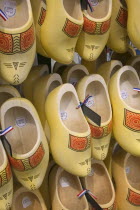 Clogs for sale with painted detail and hanging in rows.Icon   Travel  HolidaysTourism  Gift  Footware  Tradition  Netherlands