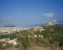 Acropolis and Lykavitos in the distance.View of the countryside with the town behind. More hills in the far distance.