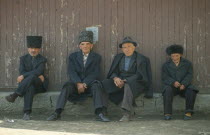 Gooderan  meeting place.  Four men sitting along wall.