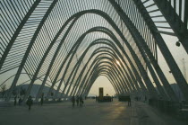 Olympic Stadium. People wandering through the walkway covered with arches in the evening.