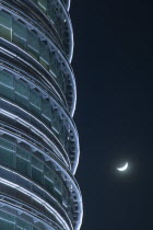 Detail of the Petronis Towers at night with a crescent moon behind.  IconNightMoonTravelTourismArchitectureSkyscrapersMoonlight