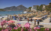 Port dAndratx  View of the beach with sunbathers and the mountain in the background.MajorcaMediterraneanTravelTourismHolidaysBeachSeasideSun bathing