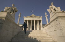 A lady walking up the steps leading to the Numismatic Museum.  HolidaysTourismTravelStatuesArchitecture