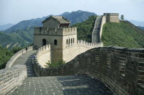 The Great Wall.  Few tourists on stretch of wall with gatehouse.