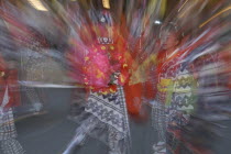 8-12 year old girls called "tekomae" in traditional Edo-era costumes  wait to proceed their neighborhood Dashi or wagon  pulled through the streets during Gion matsuri. Radial blur.