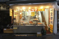 Namdaemun Market at night in December. Streetside open restaurant with staff and customers