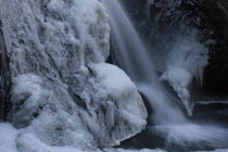 Fukuroda Waterfall detail in the winter with gushing water and ice and frozen leaves