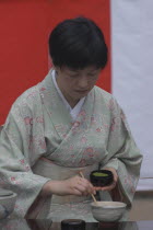Licensed tea master  Chiharu Koshikawa  prepares green tea  "macha" at a tea ceremony and  places "macha" green tea powder in bowl