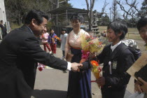 12 year old Satoshi Ui is congratulated by his principal  Mr. Saito  on his 6th grade graduation from Tako #3 Elementary School  his teacher Mrs. Horikoshi stands in middle in Kimono