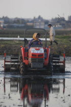 Mr. and Mrs. Katsumata  both over 70 years old  prepare rice field in spring  Mrs. Katsumata drives tractor