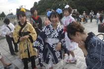 Harajuku. Members of Kyoto Rokumeikan relax after dancing at the entrance of Yoyogi Park dressed in half kimono costumes on Saturday afternoonall junior high and senior high school girls  13 - 19 yea...