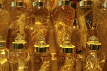 Namdaemun Market on a cold December night. Whole ginseng root on display in glass bottles