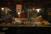 Namdaemun Market on a cold December night with a woman working at a street restaurant